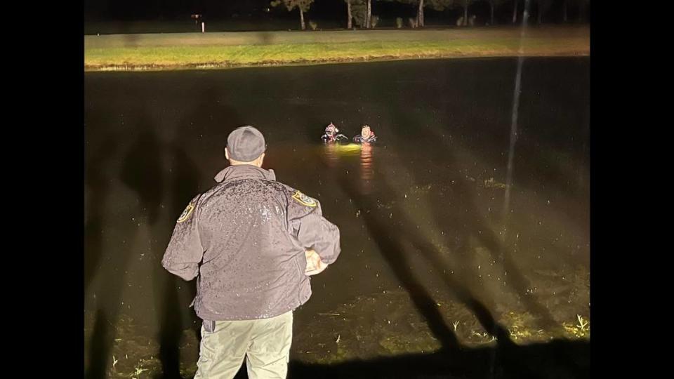 Two members of the Flagler County Sheriff’s Office Dive Team hover over the site of the vehicle while checking to make sure there are no passengers left inside.