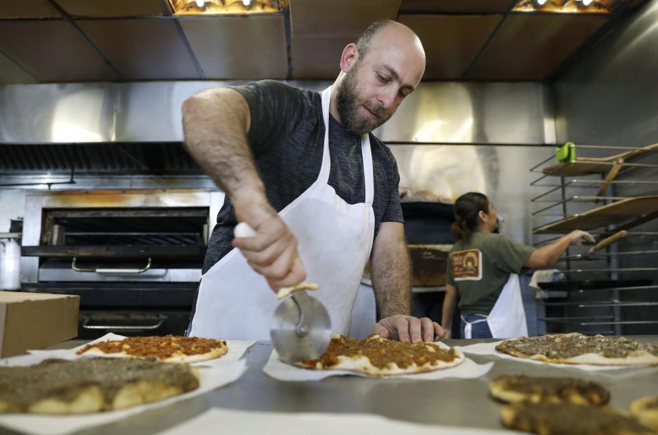 Nader Hamda, right, works at his family's restaurant, Forn Alhara, in Anaheim.