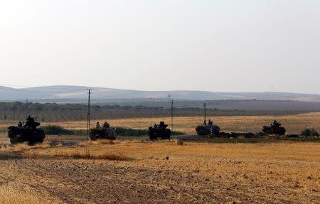 Turkish armoured personnel carriers drive towards the border in Karkamis on the Turkish-Syrian border in the southeastern Gaziantep province, Turkey, August 27, 2016. REUTERS/Umit Bektas