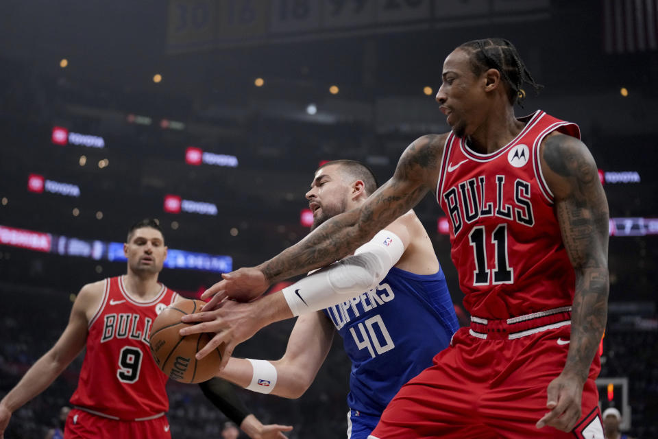 Los Angeles Clippers center Ivica Zubac (40) and Chicago Bulls forward DeMar DeRozan (11) fight for the ball during the first half of an NBA basketball game in Los Angeles, Saturday, March 9, 2024. (AP Photo/Eric Thayer)