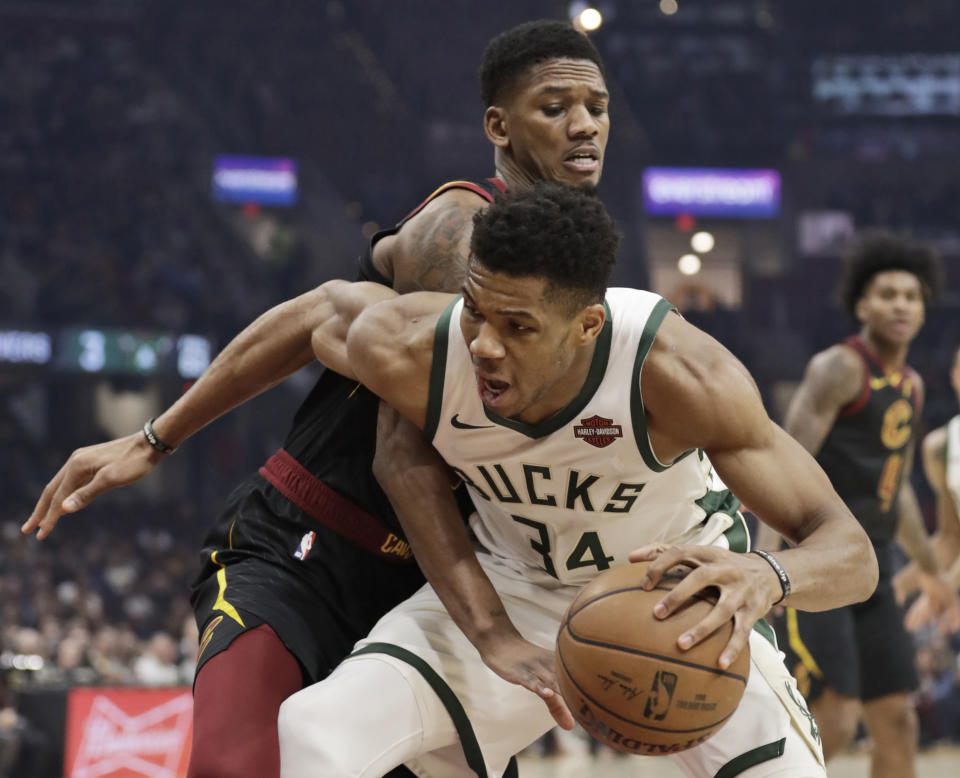 Milwaukee Bucks' Giannis Antetokounmpo (34) drives past Cleveland Cavaliers' Alfonzo McKinnie, top, in the first half of an NBA basketball game, Friday, Nov. 29, 2019, in Cleveland. (AP Photo/Tony Dejak)