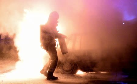 A firefighter attempts to extinguish a fire which had damaged cars after the vehicles had been set alight, in Malmo, Sweden, August 15, 2016. TT News Agency/Johan Nilsson/via REUTERS/File Photo