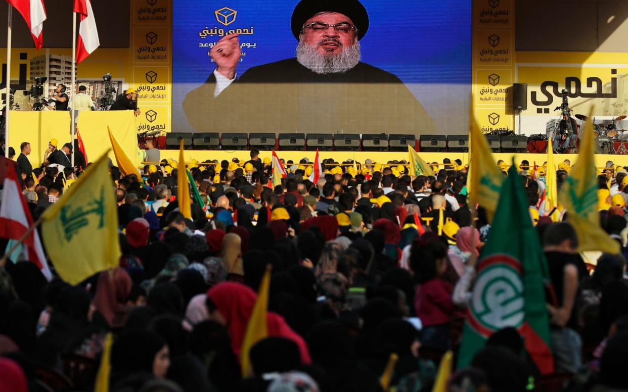 Hizbollah leader Sayyed Hassan Nasrallah delivers a broadcast speech through a giant screen during an election campaign in a southern suburb of Beirut, Lebanon. - AP