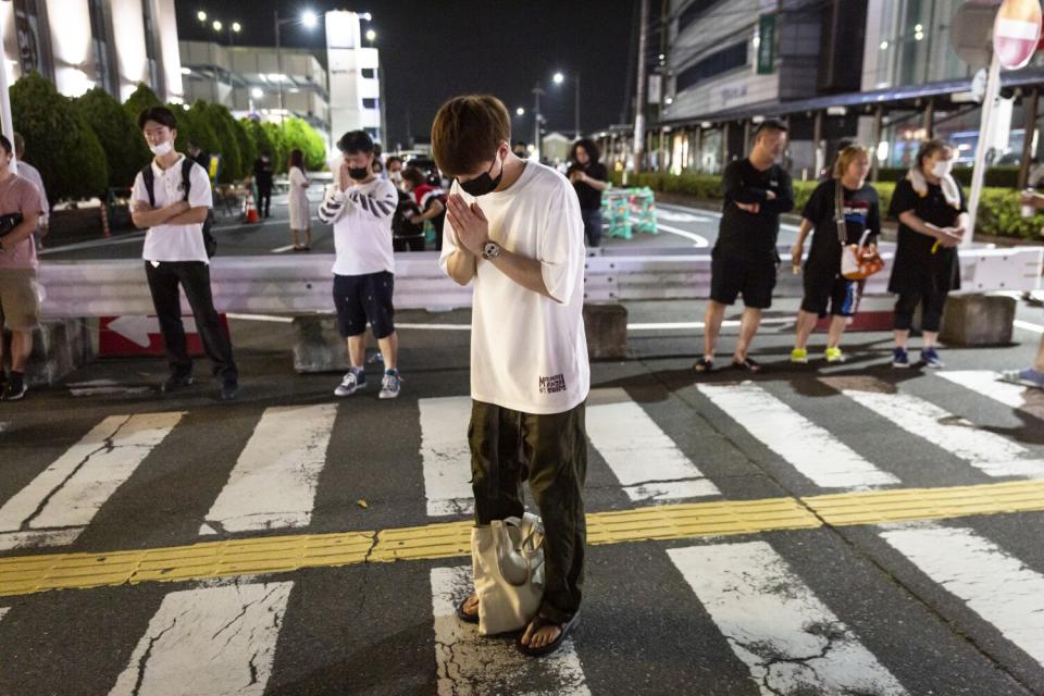 A man prays at a site outside of Yamato-Saidaiji Station where Japan's former prime minister Shinzo Abe was shot