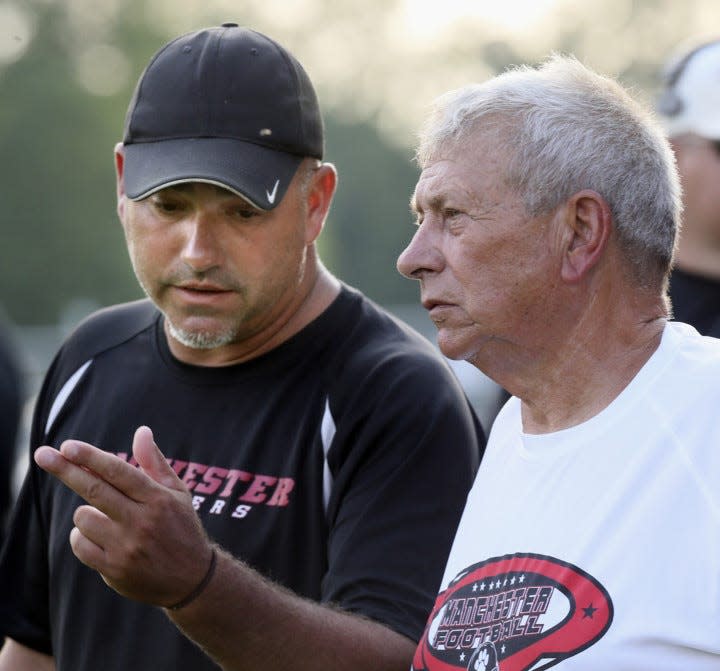 Jason France (left), a Manchester assistant coach, (left) talks with his dad Jim during a scrimmage between Manchester and Ellet at James R. France Stadium on Aug. 15, 2017, in New Franklin.