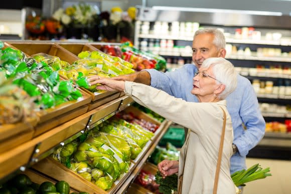 Senior couple picking out produce at a supermarket