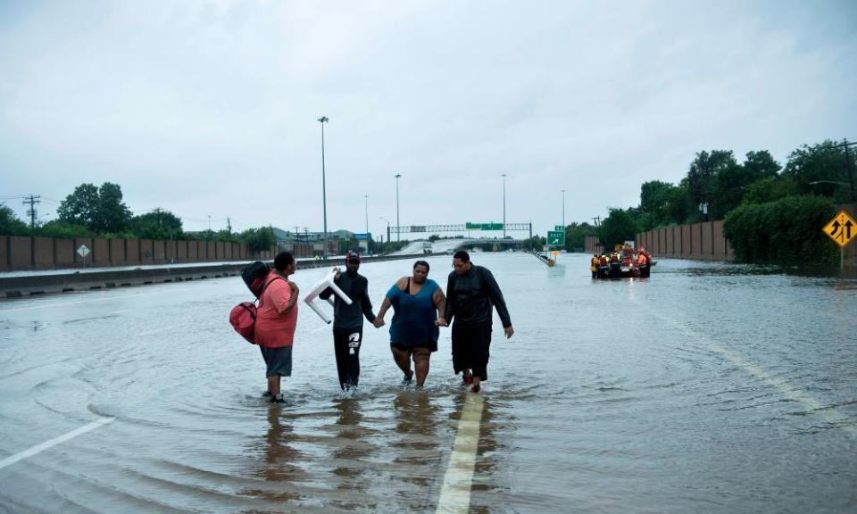 People make their way onto an I-610 overpass after being rescued from flooded homes during the aftermath of Hurricane Harvey, on 27 August 2017 in Houston, Texas.