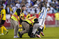 A fan is tackled as he tries to take a selfie with Argentina's player Lionel Messi as he celebrates his goal during the second half of an international friendly soccer match against Jamaica on Tuesday, Sept. 27, 2022, in Harrison, N.J. (AP Photo/Eduardo Munoz Alvarez)
