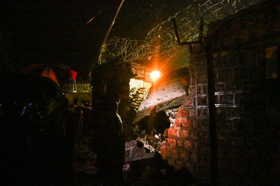 First responders inspect the wreckage of an Air India Express jet, which was carrying more than 190 passengers and crew from Dubai, after it crashed by overshooting the runway at Calicut International Airport in Karipur, Kerala, on August 7, 2020. - At least 14 people died and 15 others were critically injured when a passenger jet skidded off the runway after landing in heavy rain in India, police said on August 7. (Photo by Favas JALLA / AFP) (Photo by FAVAS JALLA/AFP via Getty Images)