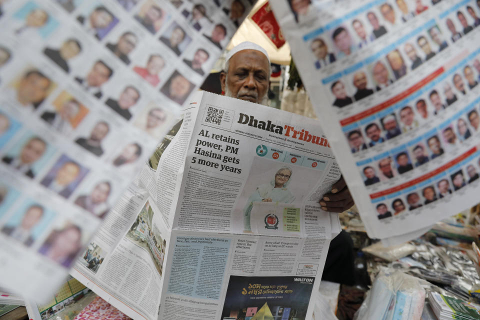 FILE - A man reads a Bangladeshi newspaper that has the news of Prime Minister Sheikh Hasina's election victory in Dhaka, Bangladesh, Monday, Jan.8, 2024. Hasina has won an overwhelming majority in Bangladesh's parliamentary election after a campaign fraught with violence and a boycott from the main opposition party, giving her and her Awami League a fourth consecutive term. (AP Photo/Mahmud Hossain Opu, File)