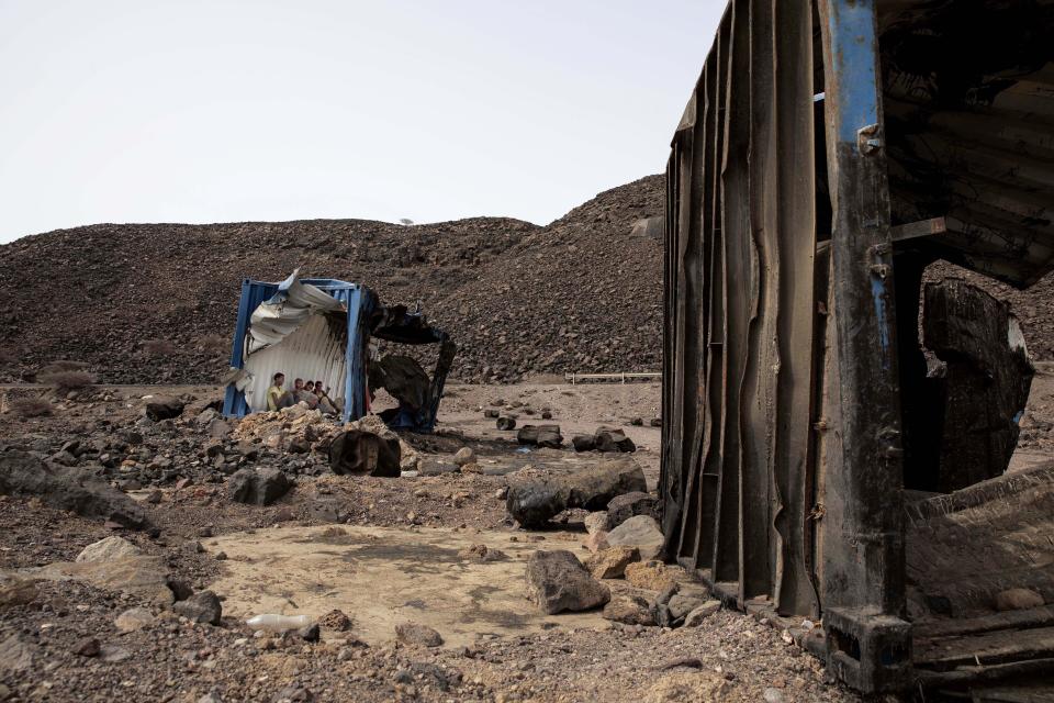 En esta imagen, tomada el 14 de julio de 2019, Mohammed Eissa, un agricultor etíope de 35 años y otros migrantes que conoció durante su viaje, se refugian dentro de un contenedor de mercancías abandonado a un lado de la autopista, cerca de Lac Assal, Yibuti. Según la OIM, en los tres últimos años, 9.000 etíopes fueron deportados cada mes. Muchos migrantes han realizado el viaje en muchas ocasiones en lo que se ha convertido en un círculo vicioso de llegadas y deportaciones. Eissa es uno de ellos. Este es su tercer viaje a Arabia Saudí. (AP Foto/Nariman El-Mofty)