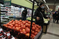 Shoppers buy fresh produces at a supermarket in Beijing, Wednesday, Dec. 28, 2022. China is on a bumpy road back to normal life as schools, shopping malls and restaurants fill up again following the abrupt end of some of the world's most severe restrictions even as hospitals are swamped with feverish, wheezing COVID-19 patients. (AP Photo/Ng Han Guan)