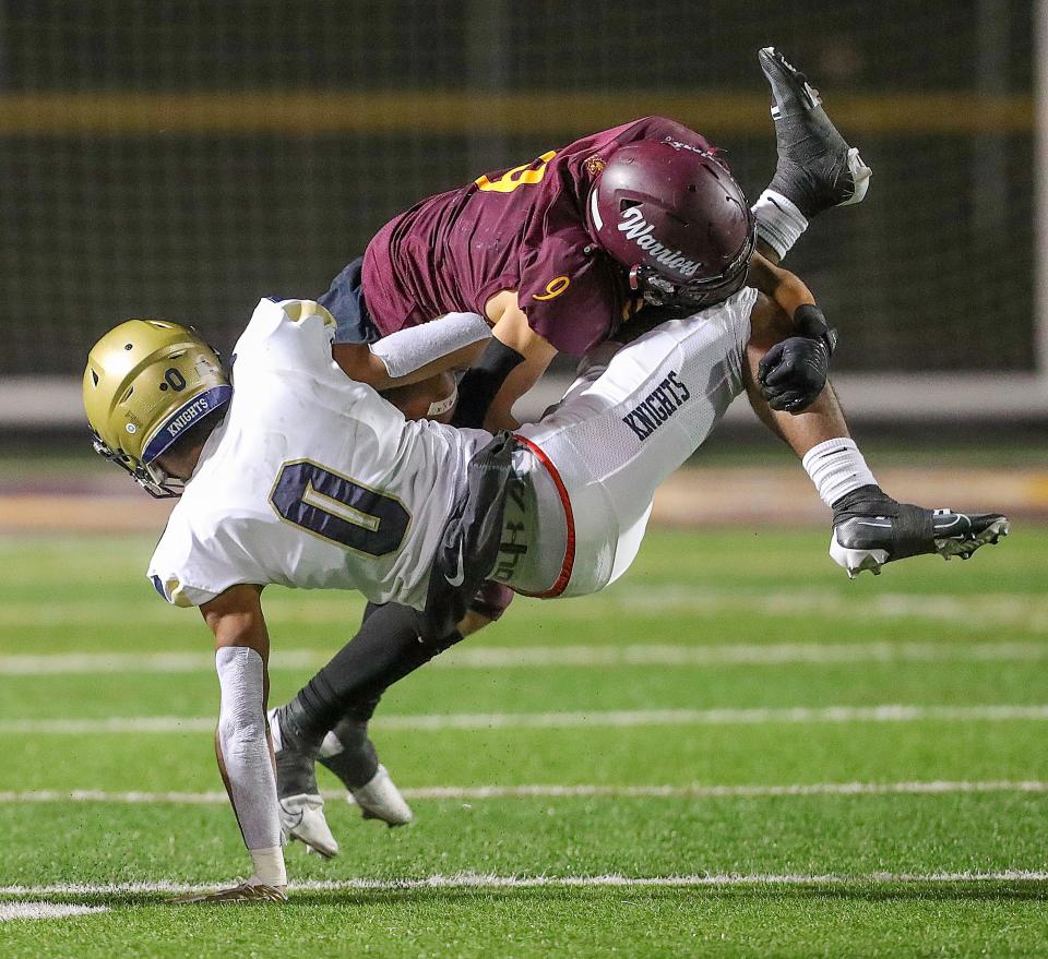 Walsh Jesuit's Aiden Henry upends Hoban's Payton Cook after a third-quarter catch in last year's game.