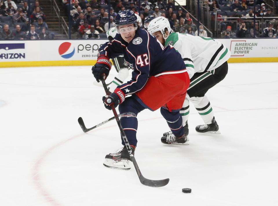 Columbus Blue Jackets center Alexandre Texier (42) drops a pass back behind Dallas Stars defenseman Jani Hakanpaa (2) during the first period of the NHL hockey game at Nationwide Arena in Columbus on Monday, Oct. 25, 2021. 