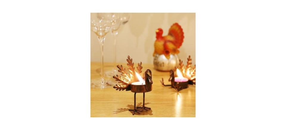 2 metal turkey tea light candle holders on a table