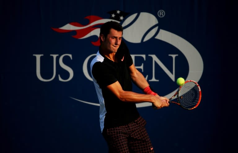 Bernard Tomic returns a shot to Damir Dzumhur during their US Open match at the USTA Billie Jean King National Tennis Center on September 1, 2015