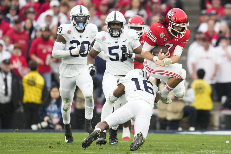 Utah quarterback Cameron Rising (7) escapes a tackle from Penn State safety Ji'Ayir Brown (16) during the first half in the Rose Bowl NCAA college football game Monday, Jan. 2, 2023, in Pasadena, Calif. (AP Photo/Marcio Jose Sanchez)