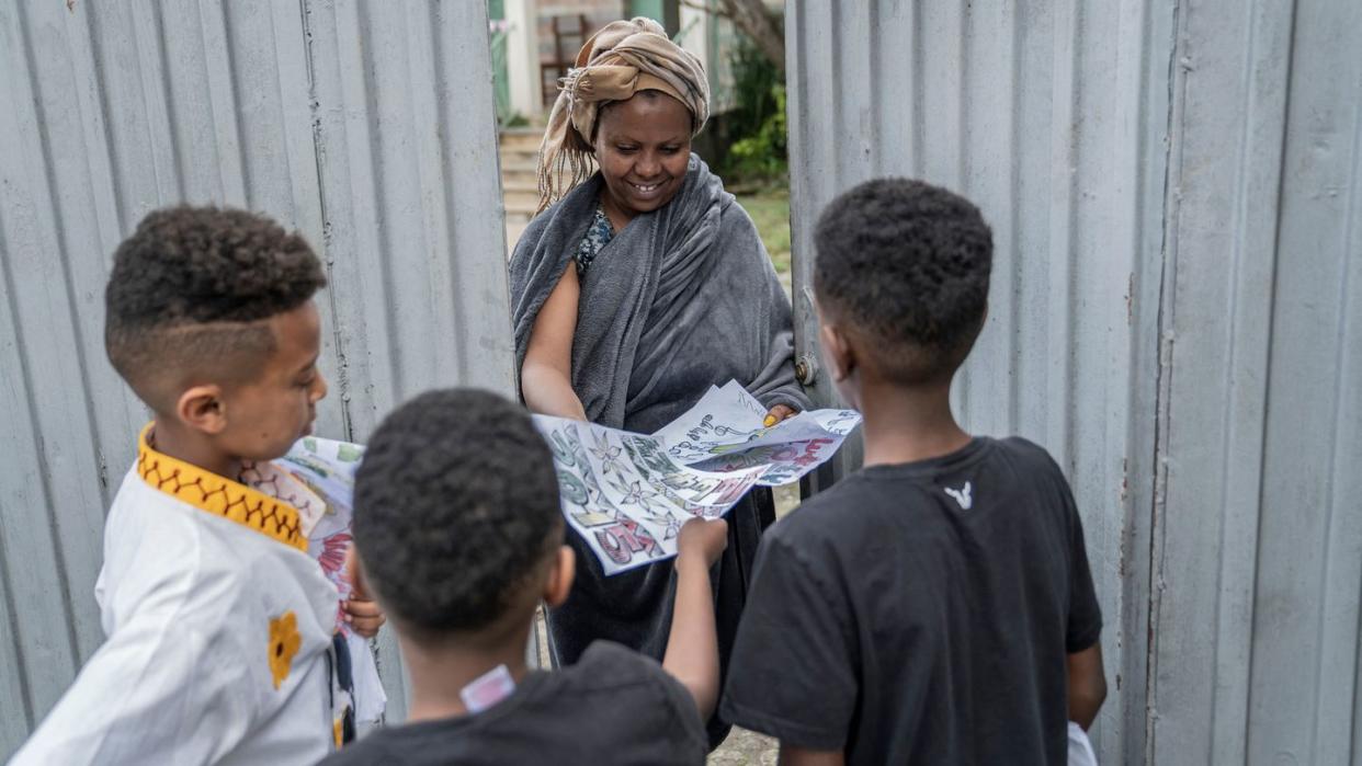 ethiopian new year enkutatash, image of three boys offering paintings to a woman in front of a silver gate