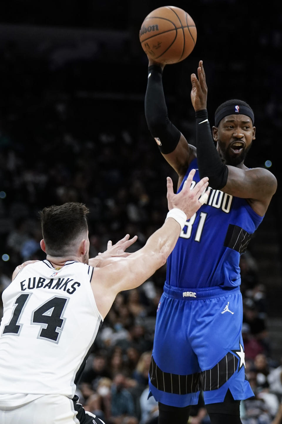 Orlando Magic's Terrance Ross looks to pass the ball as San Antonio Spurs' Drew Eubanks defends during the first half of an NBA basketball game Wednesday, Oct. 20, 2021, in San Antonio. (AP Photo/Darren Abate)