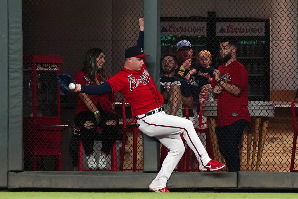 Atlanta Braves right fielder Joc Pederson catches a fly ball from San Francisco Giants' Tommy La Stella at the wall for the final out of a baseball game Friday, Aug. 27, 2021, in Atlanta. (AP Photo/John Bazemore)