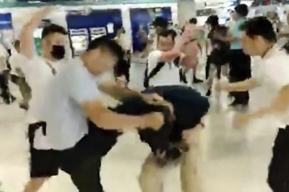 In this image taken from a July 21, 2019 video footage run by The Stand News via AP Video, white shirted men attacked a man dressed in black shirt at a subway station in Hong Kong. Hong Kong is reeling after a large gang of men in white shirts brutally beat dozens of people inside a train station in a shocking new twist to the city’s summer of protest.(The Stand News via AP Video)