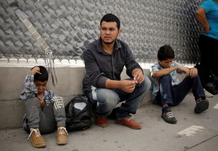 A Honduran migrant and his sons rest after returning to Mexico from the U.S. under the Migrant Protection Protocol (MPP) to wait for their court hearing for asylum seekers, in Ciudad Juarez