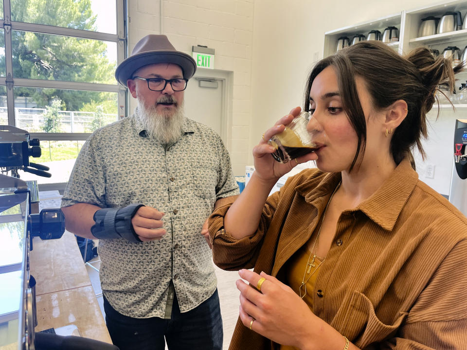 Timothy Styczynski, Head Roaster, UC Davis Coffee Center offers a taste of freshly brewed coffee to UC Davis Graduating Student Kiara DeGroen, at the Coffee Center at UC Davisin Davis, Calif. on Monday, June 17, 2024. The center which opened last month, is believed to be the first coffee-only research facility opened on any college campus in the U.S. (AP Photo/Haven Daley)