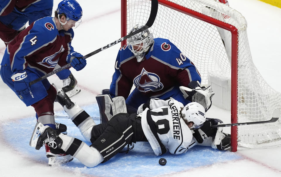 Los Angeles Kings right wing Alex Laferriere, front right, falls to the ice after driving past Colorado Avalanche defenseman Bowen Byram to put a shot on goaltender Alexandar Georgiev during the third period of an NHL hockey game Friday, Jan. 26, 2024, in Denver. (AP Photo/David Zalubowski)