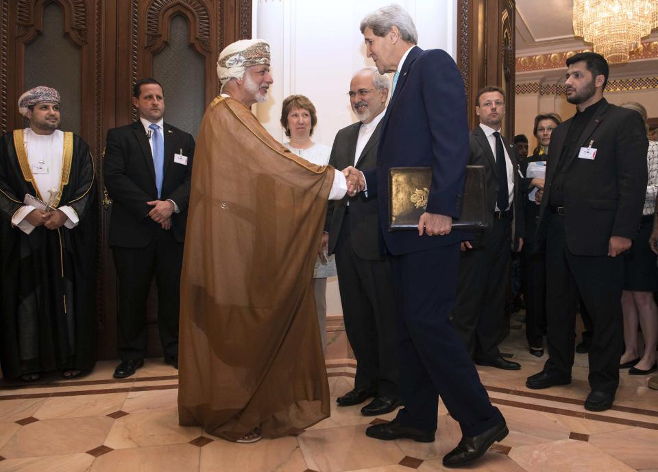 U.S. Secretary of State John Kerry (R) shakes hands with Omani Foreign Minister Yussef bin Alawi as EU envoy Catherine Ashton (rear C) and Iranian Foreign Minister Javad Zarif watch before talks in Muscat November 9, 2014. Zarif began talks with Kerry and Ashton in Oman on Sunday to try to advance efforts to end a standoff over Tehran's nuclear program, a witness said. REUTERS/Nicholas Kamm/Pool (OMAN - Tags: POLITICS ENERGY)