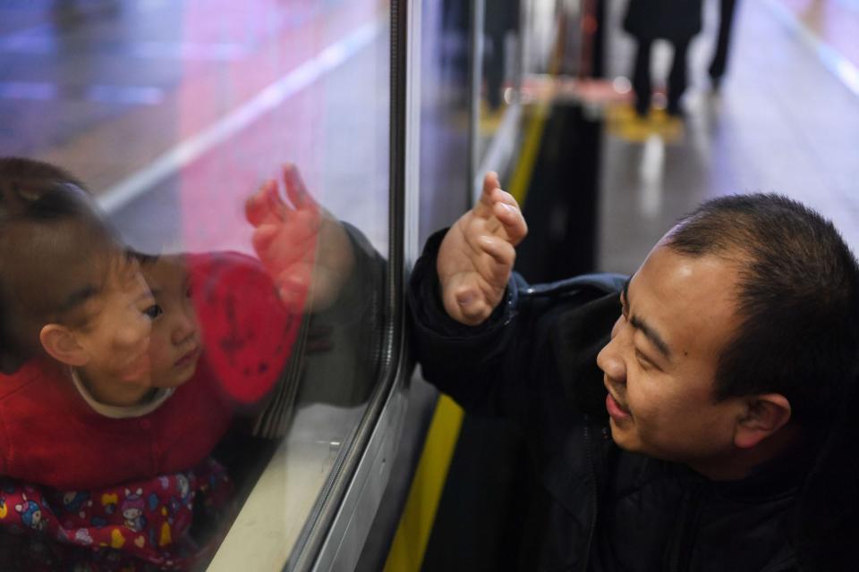 Wang Changfu R, waves goodbye to his three-year-old daughter on train K4051 at Beijing Railway Station in Beijing, capital of China, Jan. 9, 2020.