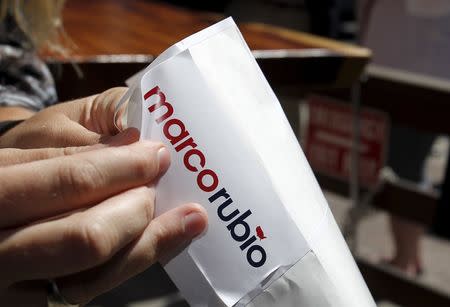 A volunteer pulls off a sticker for Marco Rubio supporters. REUTERS/Aaron Josefczyk