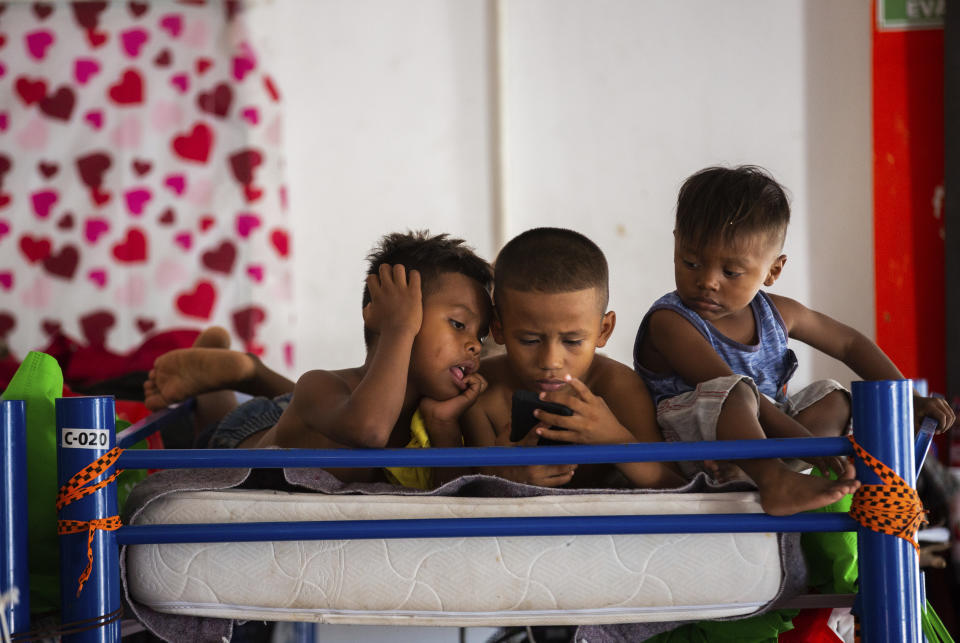 Haitian migrant children watch programing at a shelter, Friday, Sept. 17, 2021, in Ciudad Acuña, Mexico. Haitians crossed the Rio Grande freely and in a steady stream, going back and forth between the U.S. and Mexico through knee-deep water with some parents carrying small children on their shoulders. Unable to buy supplies in the U.S., they returned briefly to Mexico for food and cardboard to settle, temporarily at least, under or near the bridge in Del Rio, a city of 35,000 that has been severely strained by migrant flows in recent months. (Marie D. De Jesús/Houston Chronicle via AP)