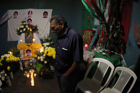 Ezequiel Mora, father of Alexander Mora Venancio stands in front of an altar with pictures of his son at his house in El Pericon, in the southern Mexican state of Guerrero, December 7, 2014. REUTERS/Jorge Dan Lopez