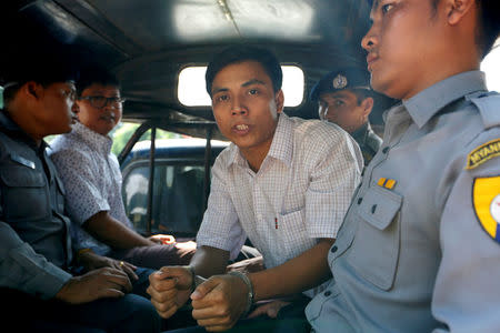 Detained Reuters journalist Kyaw Soe Oo and Wa Lone are transported in a police vehicle after a court hearing in Yangon, Myanmar April 20, 2018 . REUTERS/Ann Wang