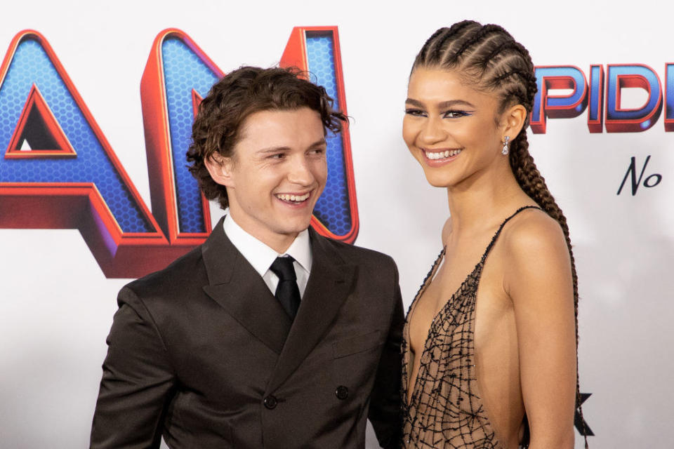 Tom's suit has a thick collar, and Zendaya's dress has a deep V neck