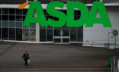 FILE PHOTO: An ASDA employee walks beneath a company logo outside a store in Manchester, northern England, July 8 , 2016. REUTERS/Phil Noble/File Photo