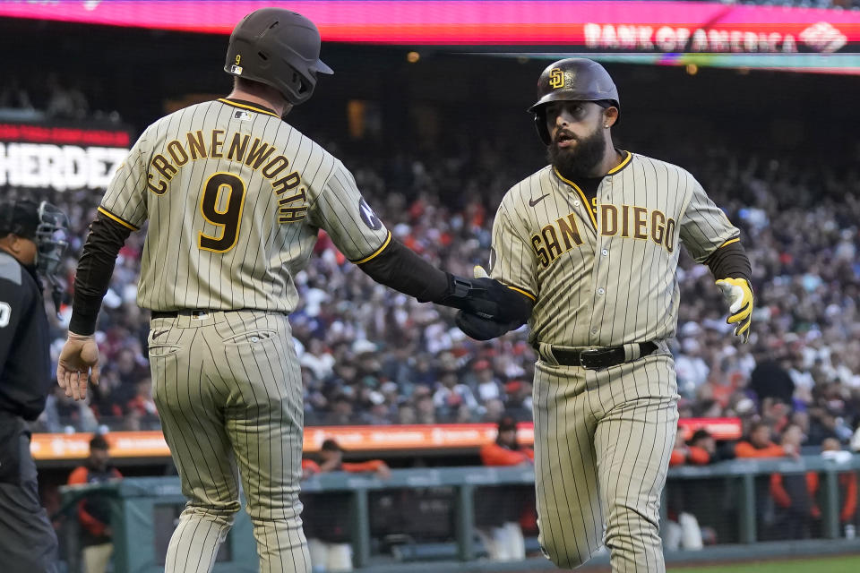 San Diego Padres' Jake Cronenworth (9) celebrates with Rougned Odor after they scored on a two-run single hit by Ha-Seong Kim during the fourth inning of a baseball game against the San Francisco Giants in San Francisco, Monday, June 19, 2023. (AP Photo/Jeff Chiu)