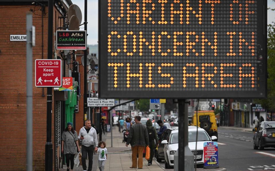 A public health digital board warns the public of a Covid-19 variant of concern affecting the community in Bolton, northwest England  - AFP