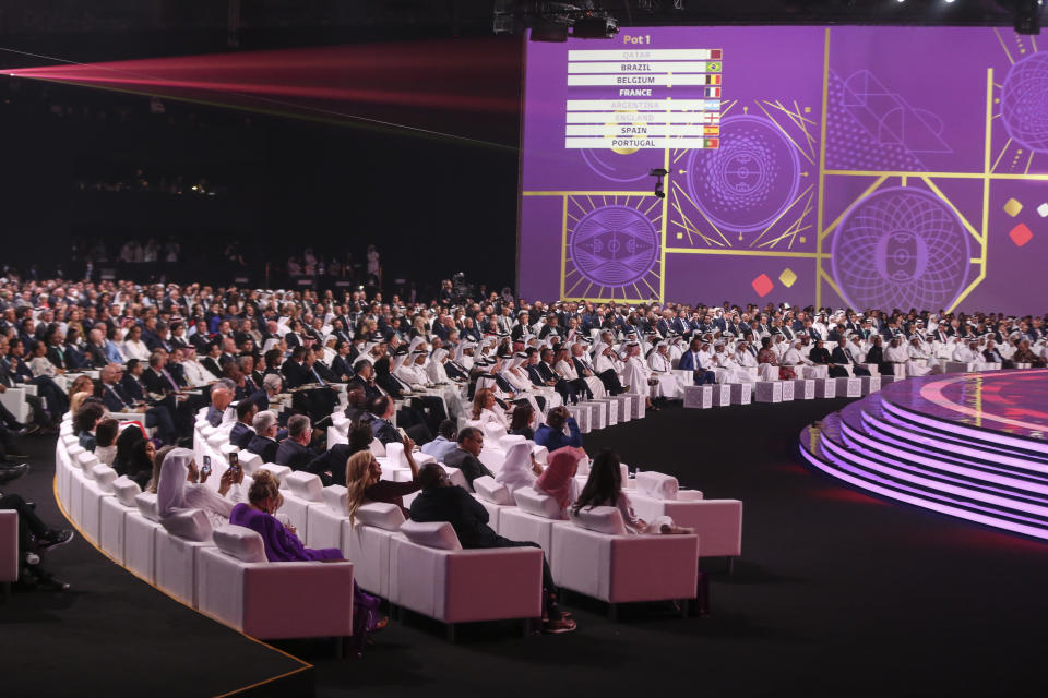 FILE - Spectators follow the 2022 soccer World Cup draw at the Doha Exhibition and Convention Center in Doha, Qatar, Friday, April 1, 2022. Many think Qatar is hosting the event to project its influence, build international connections and move past a human-rights record criticized by international groups and workers’ advocates. Critics describe the 2022 World Cup, which starts Sunday, as a classic case of “sportswashing” — using sports to change a country or company's image. (AP Photo/Hussein Sayed, File)