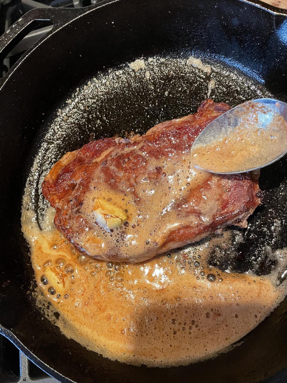 Slightly tilt your skillet towards you to pool the butter on one side to make basting the steak easier. (Katie Stilo)