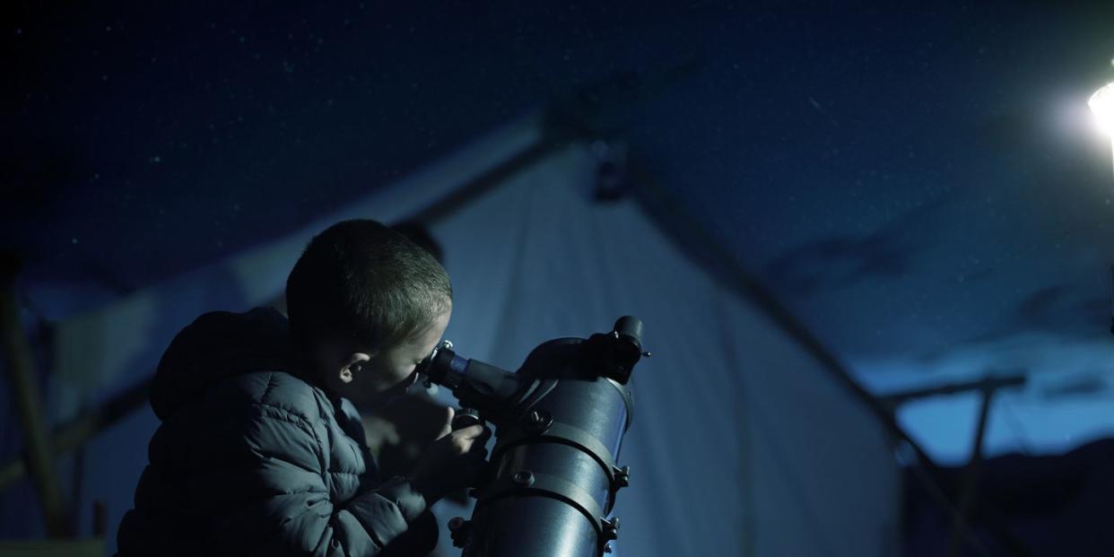 boy looking through telescope