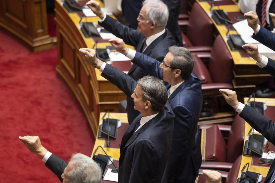 Greece's former Prime Minister and leader of New Democracy party Kyriakos Mitsotakis, center, takes the oath during a swearing in ceremony at the parliament in Athens, Greece, Sunday, May 28, 2023. Newly elected Greek lawmakers were sworn in Sunday, but the Parliament elected on May 21 could be dissolved as early as Monday and a new election campaign start for another election, on June 25. (AP Photo/Yorgos Karahalis)