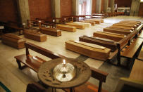 FILE - In this Thursday, March 26, 2020 file photo, coffins are lined up on the floor in the San Giuseppe church in Seriate, one of the areas worst hit by coronavirus, near Bergamo, Italy, waiting to be taken to a crematorium. European Union leaders are preparing for a new virtual summit, which will take place Thursday, April 23, 2020, to take stock of the damage the coronavirus has inflicted on the lives and livelihoods of the bloc's citizens and to thrash out a more robust plan to revive their ravaged economies. (AP Photo/Antonio Calanni, File)