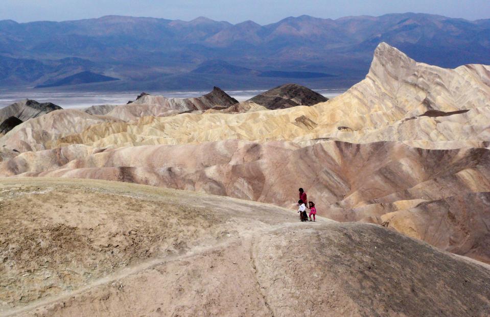 A tourist walks along a ridge at Death Valley National Park, Calif.