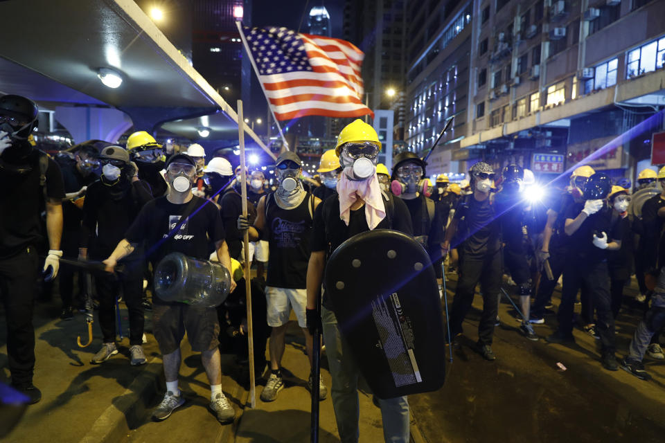FILE - Protesters prepare to confront riot police while waving a U.S. flag in Hong Kong on July 21, 2019. (AP Photo/Vincent Yu, File)