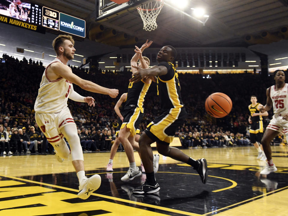 Wisconsin forward Tyler Wahl (5) passes the ball around Iowa forward Ladji Dembele (13) during the first half of an NCAA college basketball game, Saturday, Feb. 17, 2024, in Iowa City, Iowa. (AP Photo/Cliff Jette)