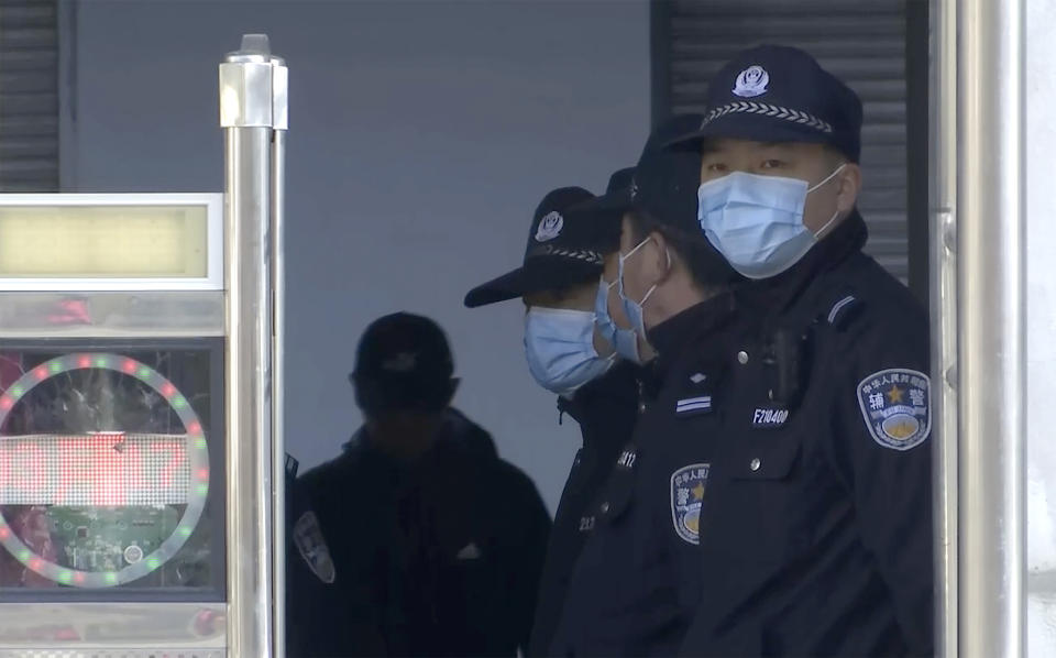 In this image taken from video, security officers stand guard at an entrance to a court building in Dandong in northeastern China's Liaoning Province, Friday, March 19, 2021. China was expected to open the first trial Friday for Michael Spavor, one of two Canadians who have been held for more than two years in apparent retaliation for Canada's arrest of a senior Chinese telecom executive. (AP Photo)