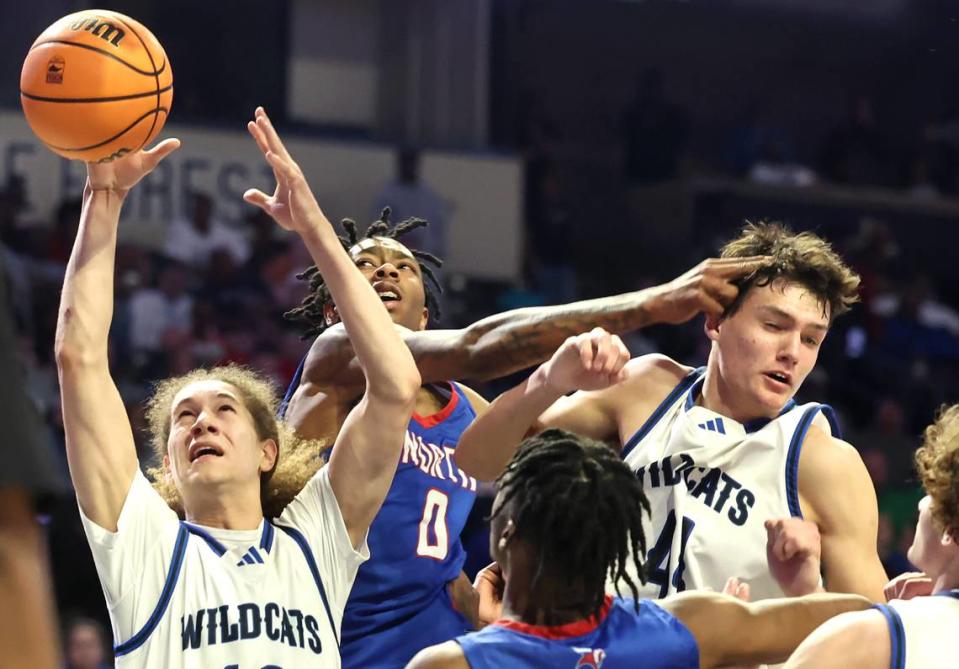 Lake Norman’s Santana Lynch, left, grabs control of a rebound as North Meck’s Isaiah Evans, center, attempts to knock the ball away during the AAAA Regional Championship on Thursday, March 14, 2024 at Lawrence Joel Veterans Memorial Coliseum in Winston-Salem, NC. North Meck defeated Lake Norman 65-61. JEFF SINER/jsiner@charlotteobserver.com