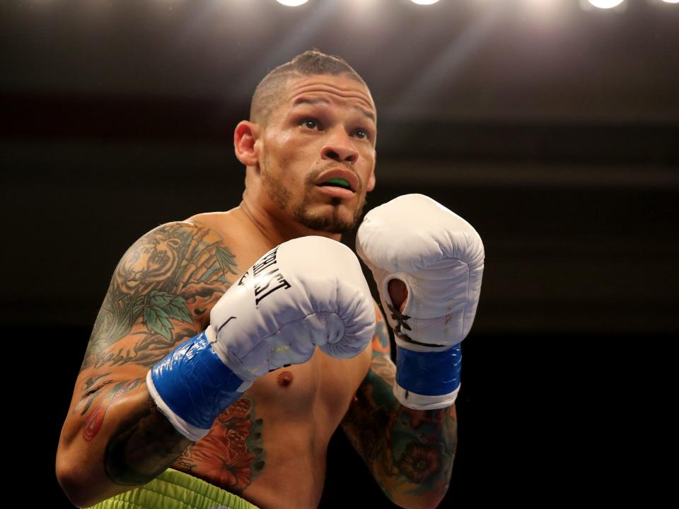 orlando curz in the ring with his boxing gloves on and hands held up