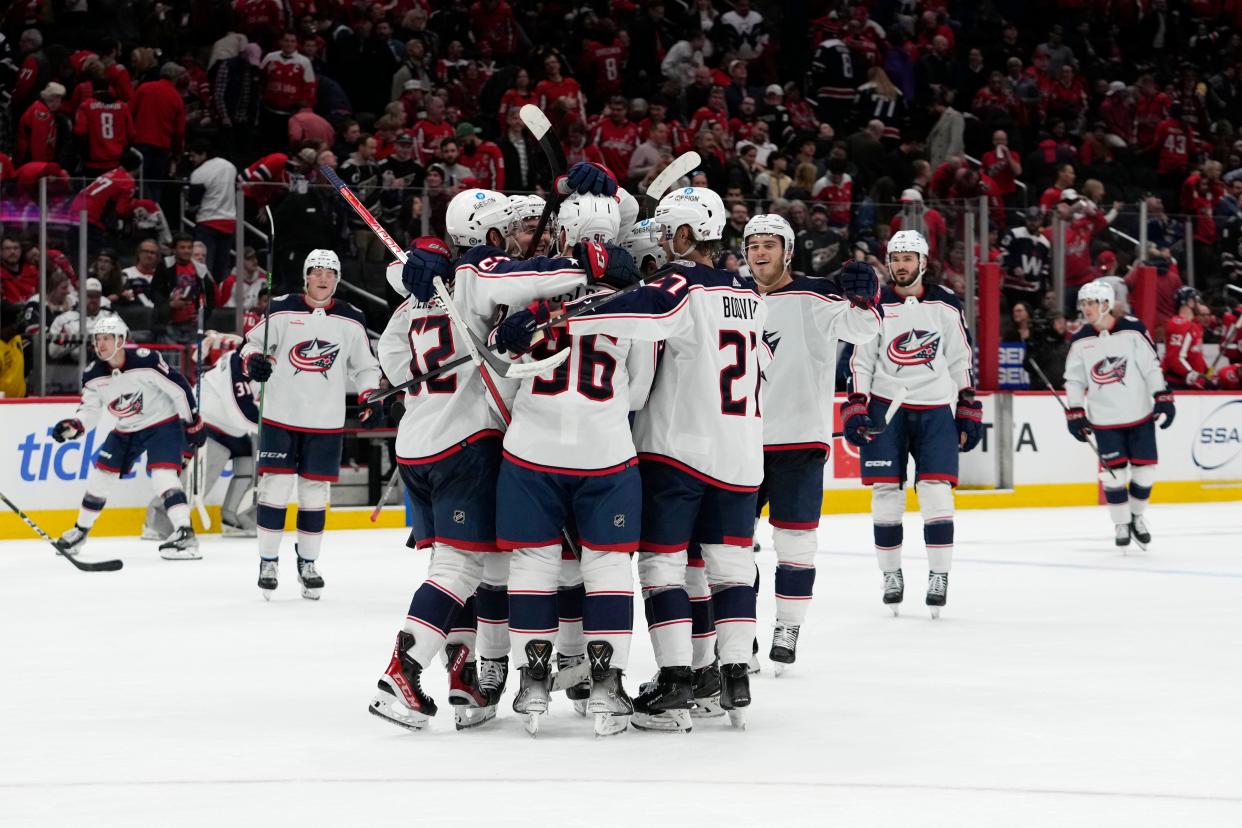 Columbus Blue Jackets center Jack Roslovic (96) celebrates his game-winning goal with teammates during overtime of an NHL hockey game against the Washington Capitals, Tuesday, March 21, 2023, in Washington. The Blue Jackets won 7-6. (AP Photo/Carolyn Kaster)